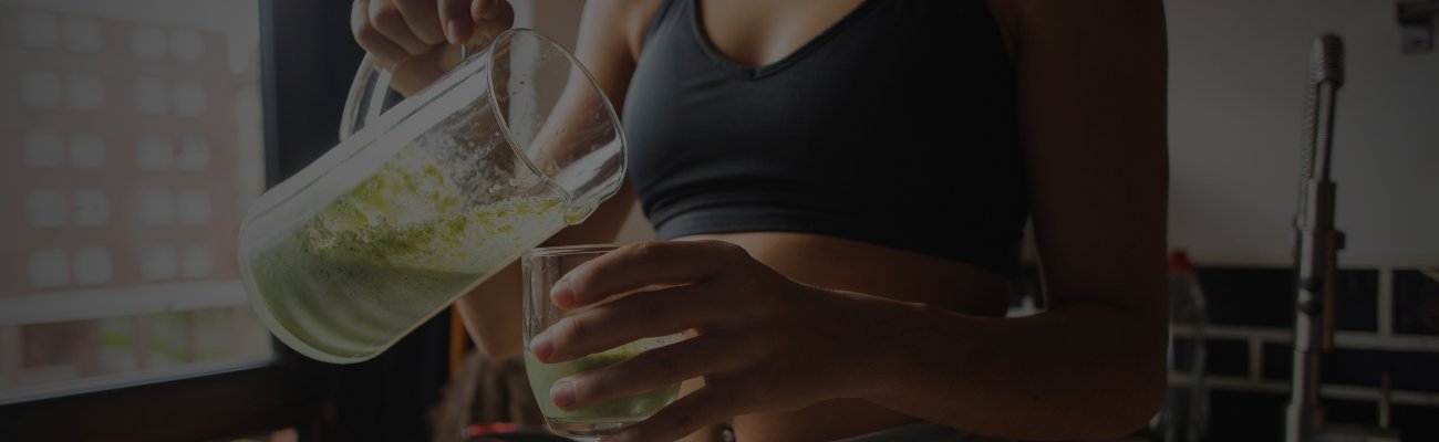 Frau trinkt Vitamine aus einem Glas